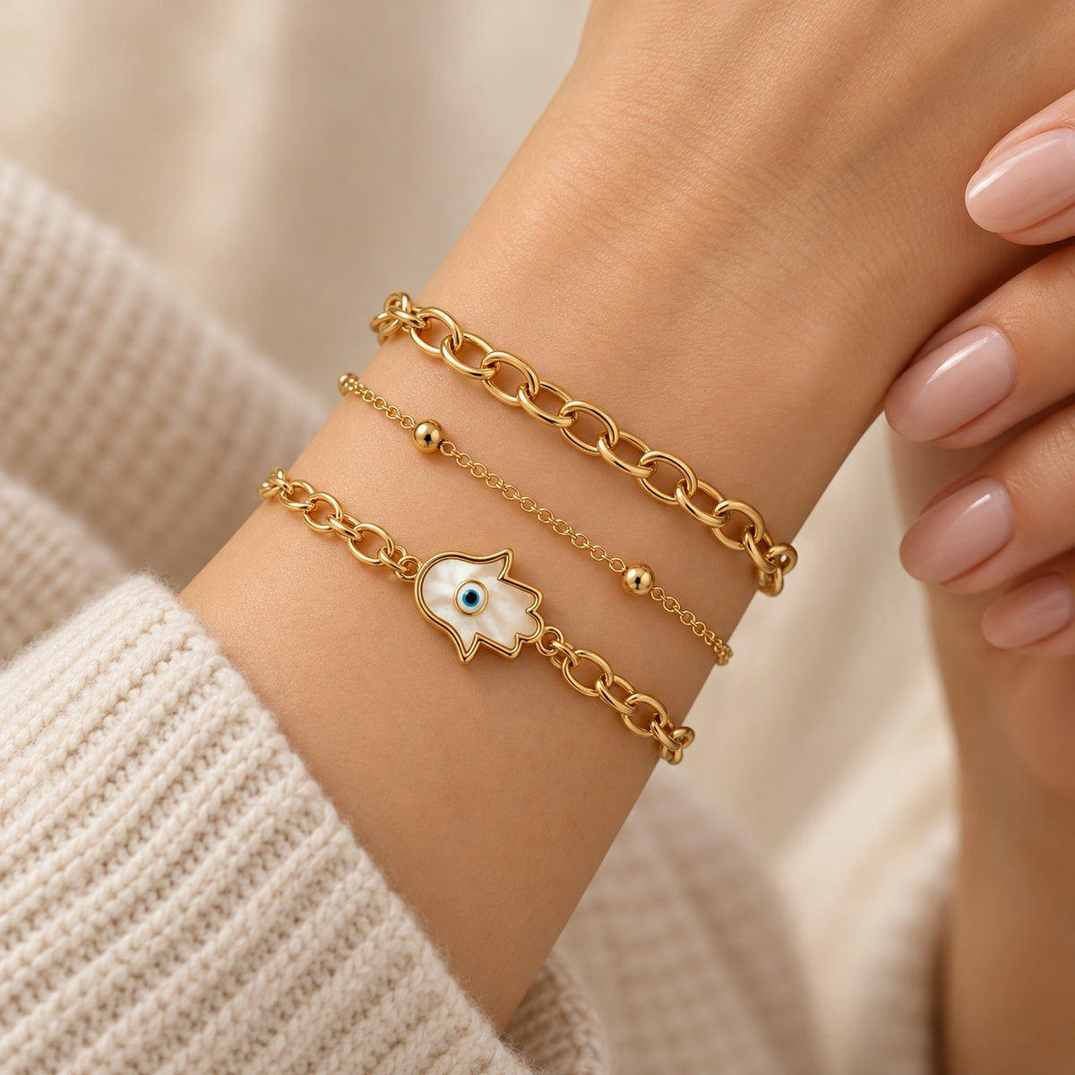 Woman wearing the gold hamsa evil eye bracelet set of 3 stacked on her wrist