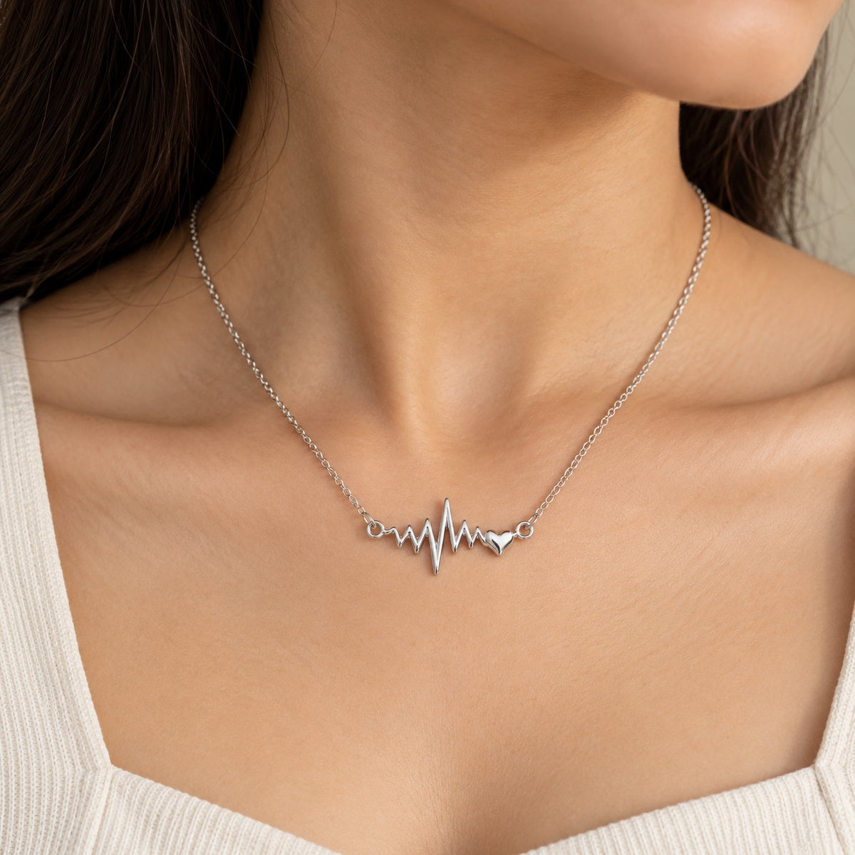 Woman wearing a silver heartbeat ECG pendant chain necklace