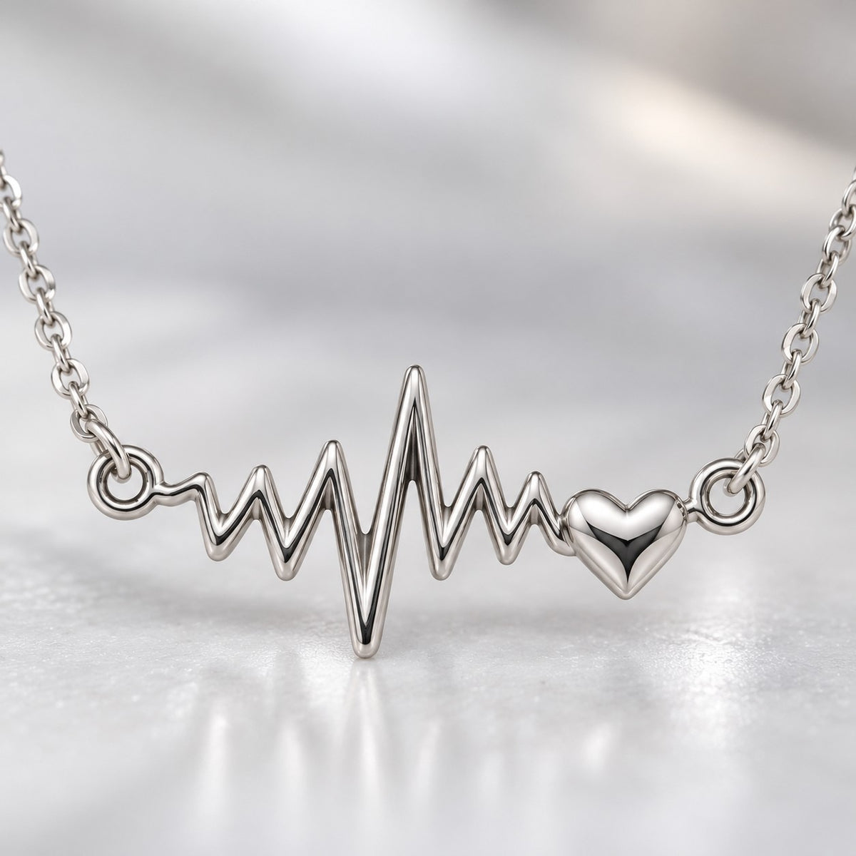 Close-up of the silver heartbeat ECG line pendant with tiny heart