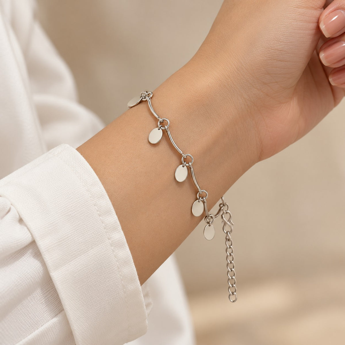 Woman wearing the silver oval disc charm bracelet on her wrist