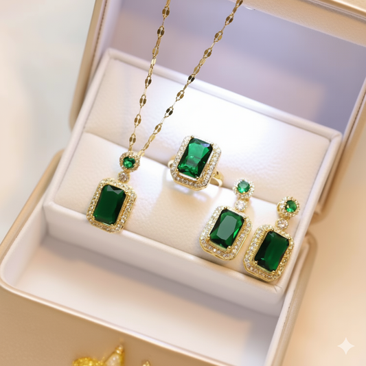 Green gemstone jewelry set with gold accents on a white box