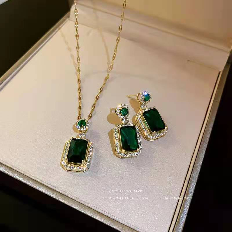 Green gemstone necklace and earrings on a jewelry box