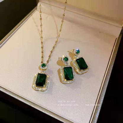 Green gemstone necklace and earrings on a jewelry box