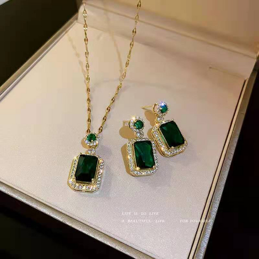 Green gemstone necklace and earrings on a jewelry box