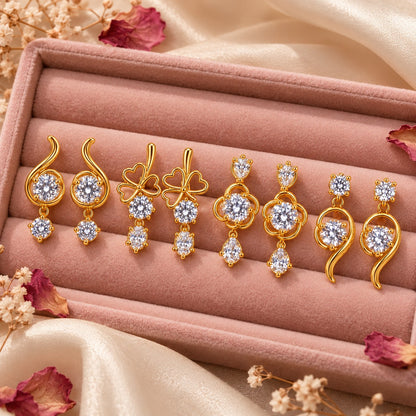 Assorted gold AD stone drop earrings on a blush velvet jewellery box with dried petals