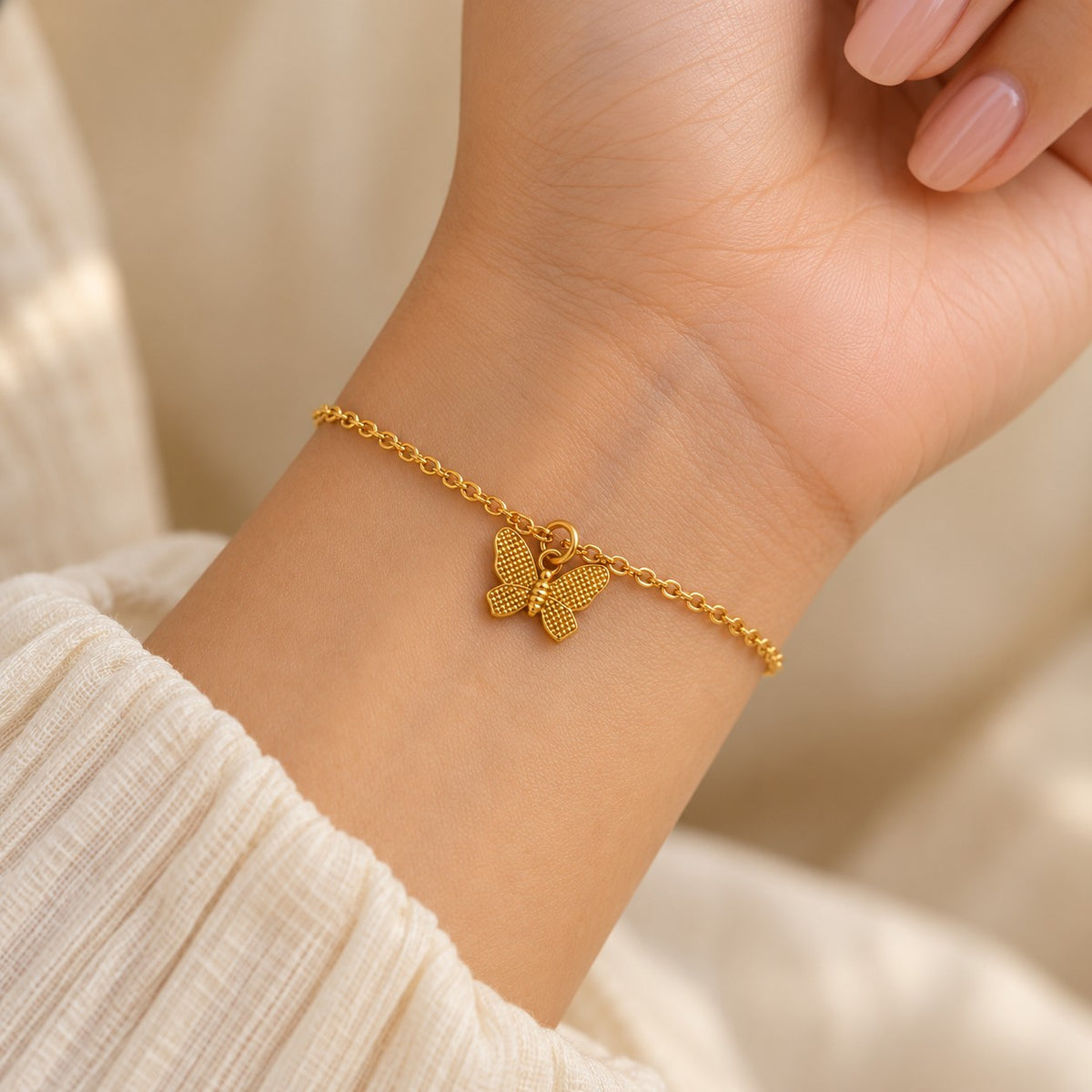 Woman wearing the gold butterfly charm bracelet on her wrist
