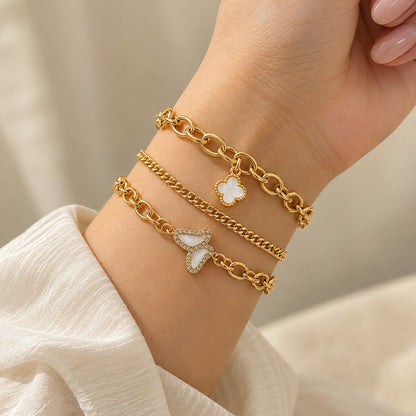 Woman wearing the gold clover and butterfly bracelet set of 3 stacked on her wrist