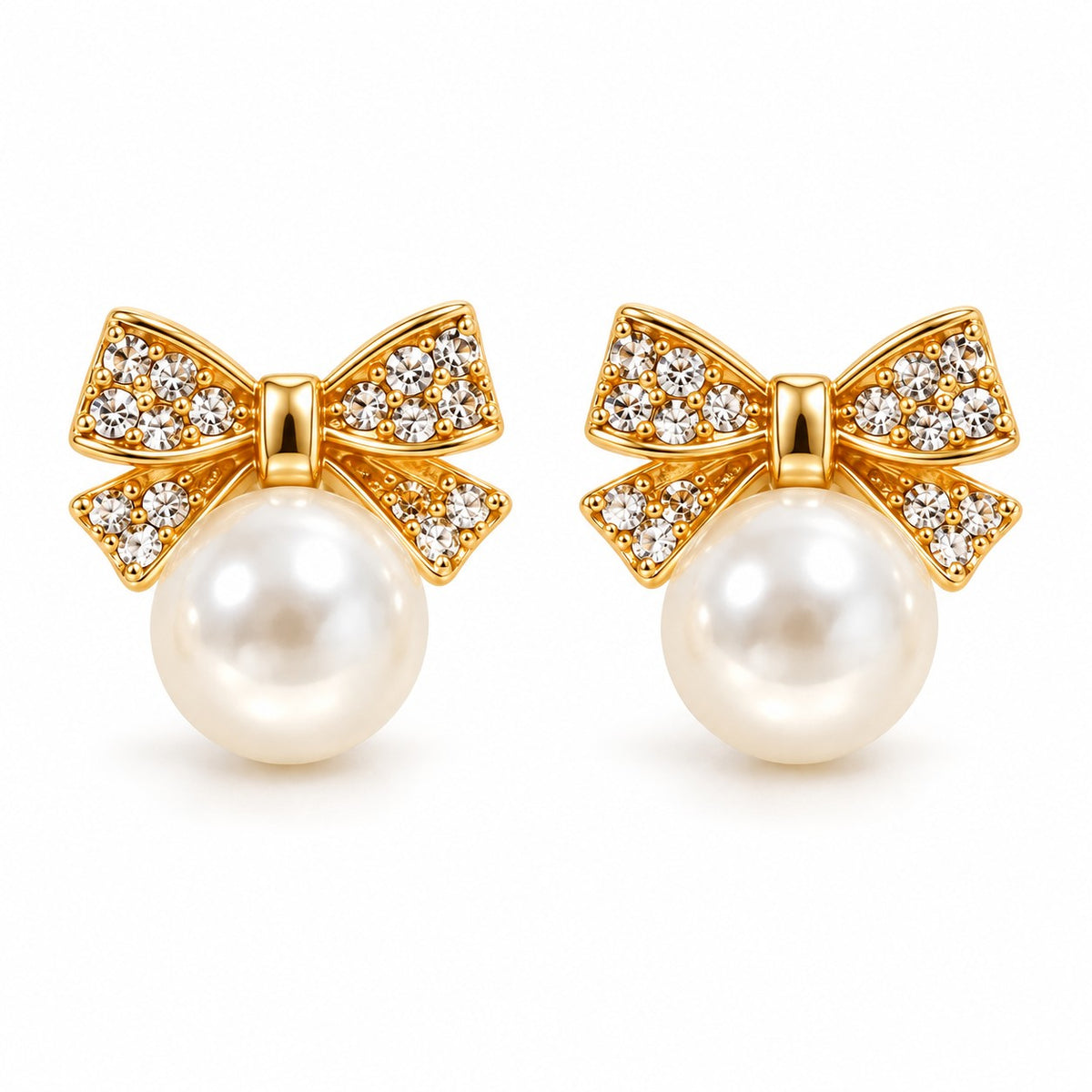 Gold crystal bow pearl stud earrings with faux pearl drop on a white background