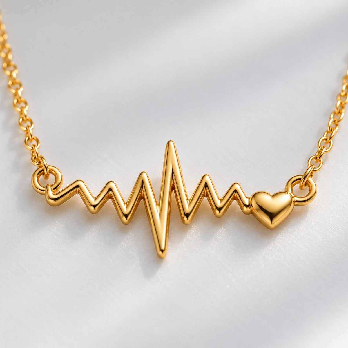 Close-up of the gold heartbeat ECG line pendant with tiny heart