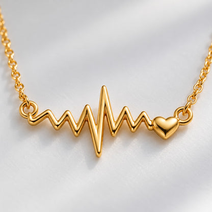 Close-up of the gold heartbeat ECG line pendant with tiny heart