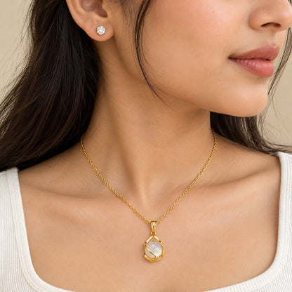 Woman wearing the gold moonstone pendant necklace with matching crystal stud earrings