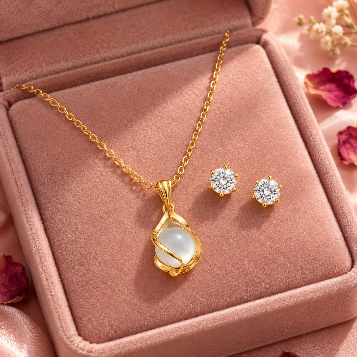 Gold moonstone pendant necklace and stud earrings set on a blush velvet jewellery box