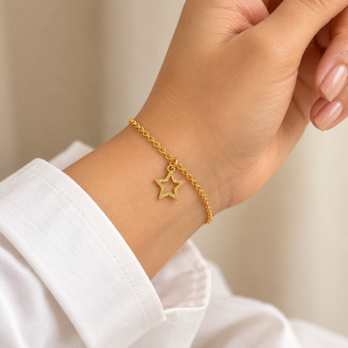 Woman wearing the gold star charm bracelet on her wrist