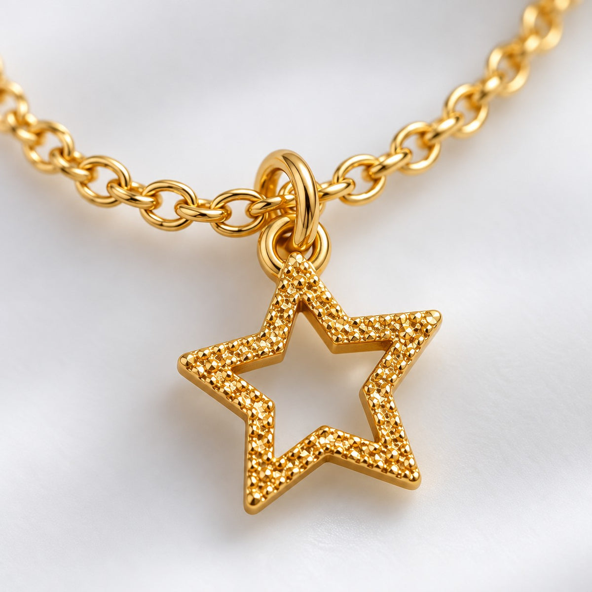 Close-up of the textured open star charm on the gold star charm bracelet