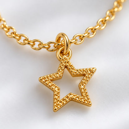 Close-up of the textured open star charm on the gold star charm bracelet