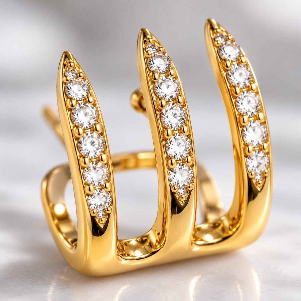 Macro detail of crystal-lined gold spike prongs on a triple spike hoop earring