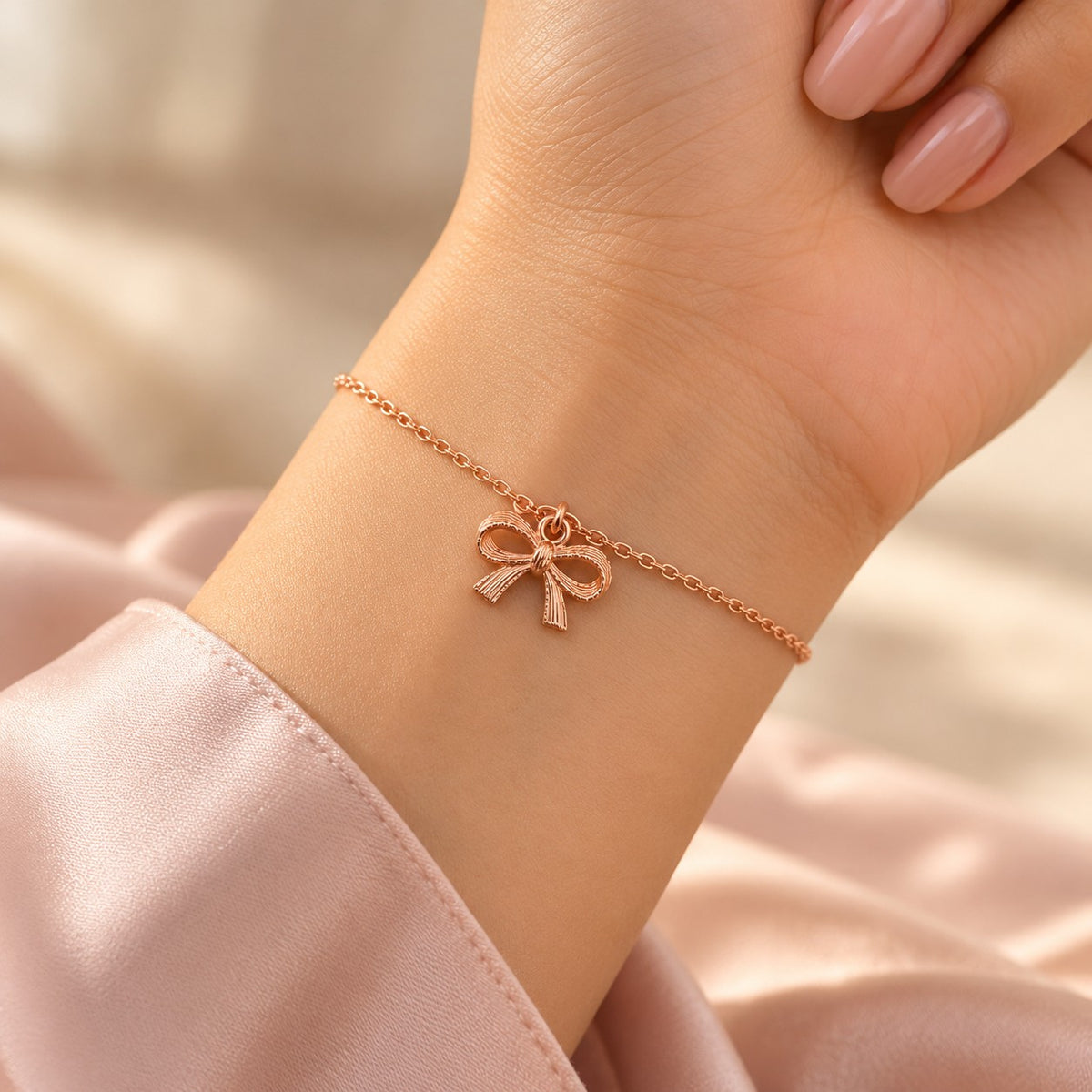 Woman wearing the rose gold bow charm bracelet on her wrist