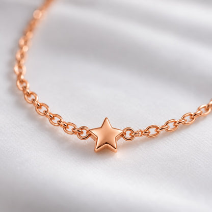 Close-up of the tiny five-point star on the rose gold chain necklace