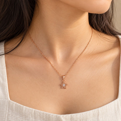 Woman wearing a rose gold star solitaire pendant chain necklace