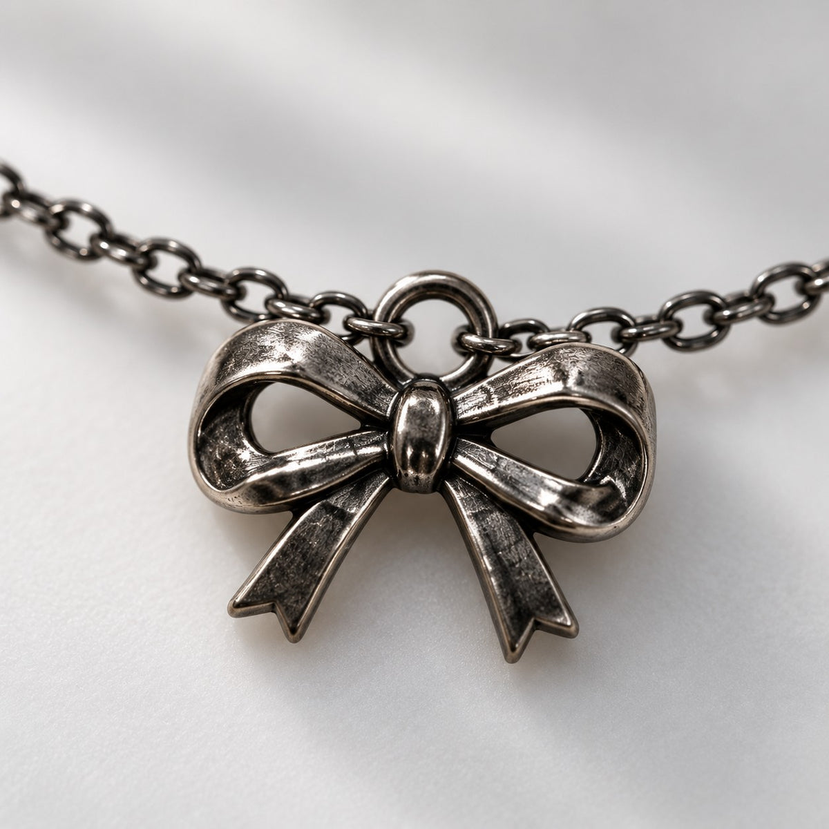 Close-up of the antique silver ribbon bow charm on the silver bow charm bracelet
