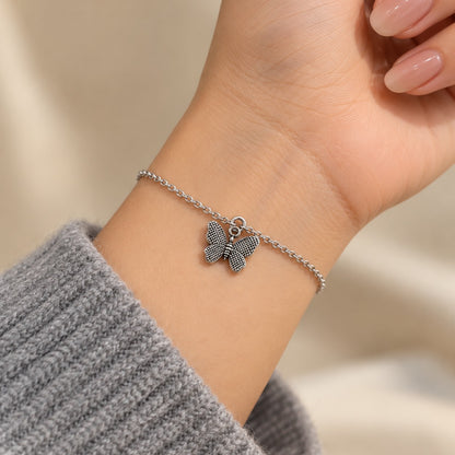 Woman wearing the silver butterfly charm bracelet on her wrist