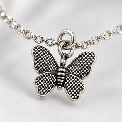 Close-up of the dotted-texture wings on the silver butterfly charm bracelet