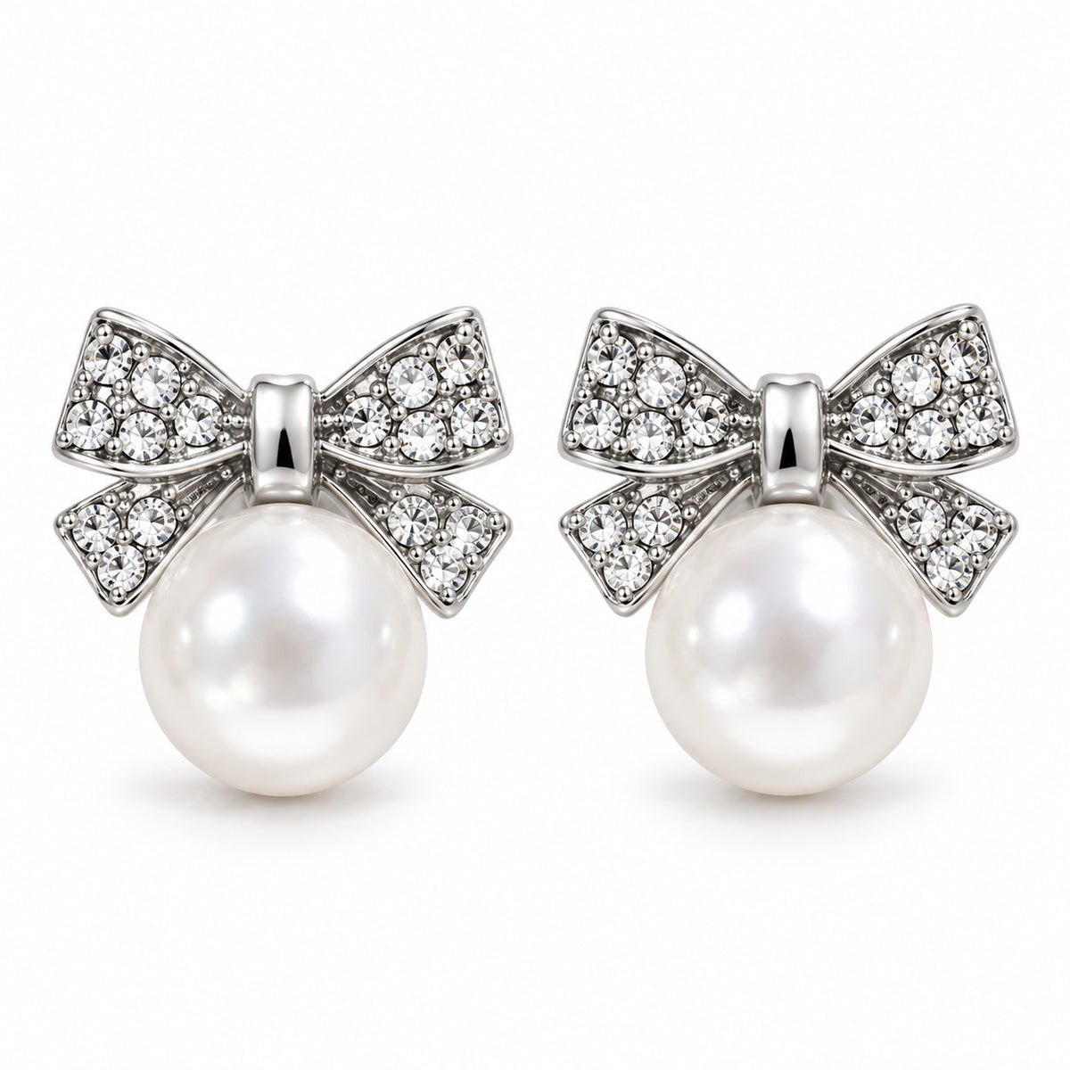 Silver crystal bow pearl stud earrings with faux pearl drop on a white background
