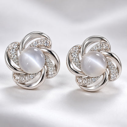 Close-up of the milky cat eye stone and crystal swirl petals on a silver stud earring