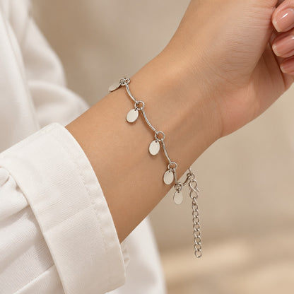 Woman wearing the silver oval disc charm bracelet on her wrist