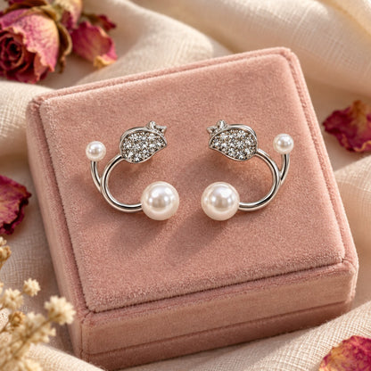Silver pearl open hoop stud earrings on a blush velvet jewellery box with dried petals