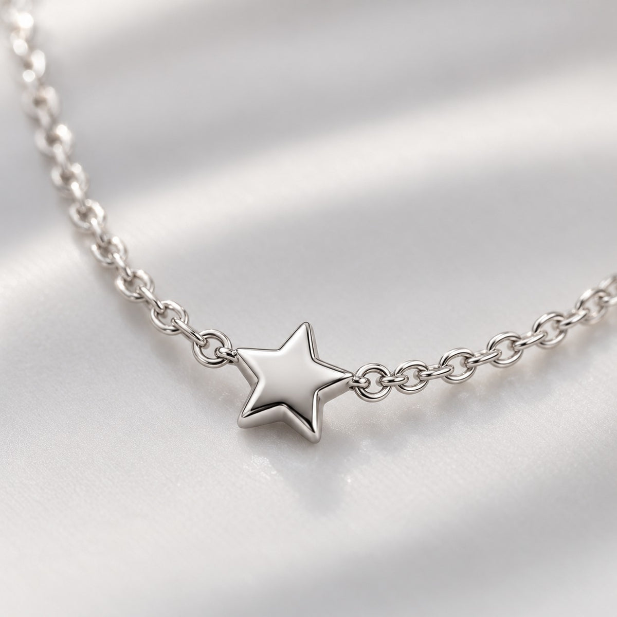 Close-up of the tiny five-point star on the silver chain necklace